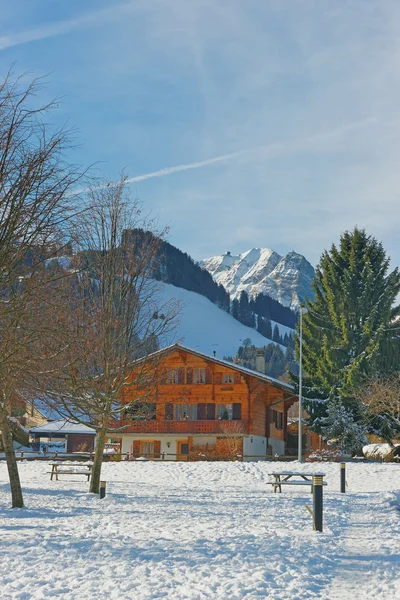 Słoneczny zimowy pejzaż z Alpine chalet — Zdjęcie stockowe