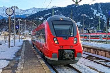 Shiny red train stopped at the Garmisch-Partenkirchen railway station