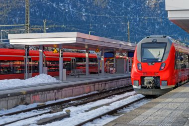 Shiny red high-speed train is waiting for passengers