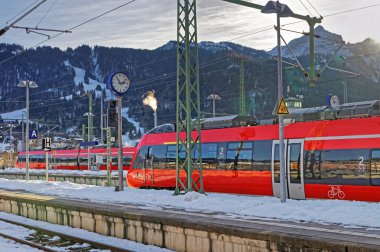 Shiny red train stopped at the Garmisch-Partenkirchen railway station