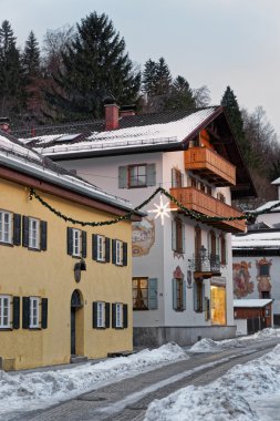 Duvarlarda benzersiz duvar resimleri ile Garmisch-Partenkirchen karlı sokak