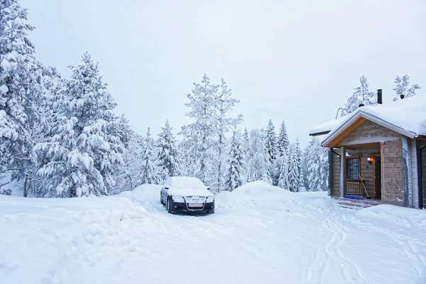 Auto geparkeerd in de buurt van een houten huisje in Ruka in Finland — Stockfoto