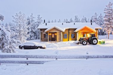 Traktör Finlandiya Ruka Ahşap Cottage de kar temizliyor