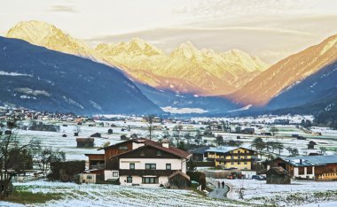 View of countryside in snow covered Switzerland at sunset clipart