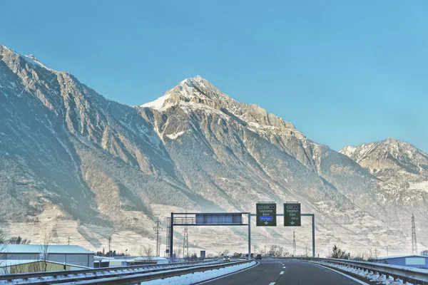 Widok z drogi z drogą śpiewa w Szwajcarii w zimie — Zdjęcie stockowe