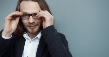 Uzun saçlı başarılı beyaz iş adamının yakın portresi kameraya bakıp gülümsüyor..