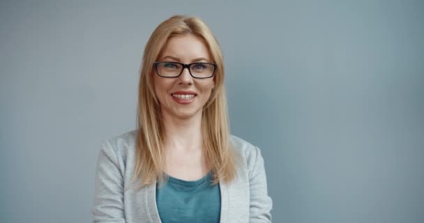 Portré okos boldog gyönyörű fehér nő szőke haj szemüvegben nézi kamera lencse mosolygós. — Stock videók