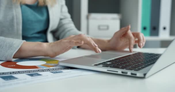 Primer plano de la señora de negocios inteligente escribiendo correo electrónico en su computadora portátil mientras está sentada en la oficina en el escritorio. — Vídeos de Stock