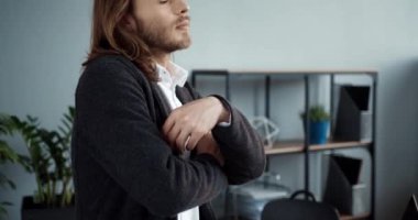 Ofisinde kollarını kavuşturup dikkatlice yukarı bakan başarılı beyaz iş adamının portresini yakından çek..