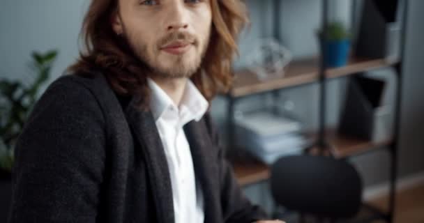 Närbild porträtt av framgångsrik kaukasisk affärsman i eleganta kläder sitter på sitt kontor och tittar på kameran ler. — Stockvideo
