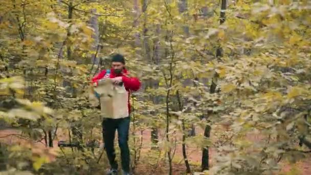 A fiatal kaukázusi férfi utazó eltéved az erdőben, és megpróbálja megtalálni a módját, hogy megnézze a papírtérképet a kezében. — Stock videók