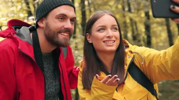 Primer plano de la joven pareja feliz grabando mensaje de vídeo en el teléfono inteligente desde su primera caminata en el bosque. — Vídeos de Stock