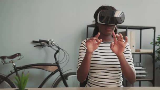 Młoda, piękna afrykańska dziewczyna pracująca nad projektem w nowoczesnym biurze w kasku wirtualnej rzeczywistości. Technologie przyszłości. — Wideo stockowe