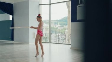 Şirin yetenekli kız çemberi kullanarak Ritmik Jimnastik Şampiyonası 'nda performans sergilemek için prova yapıyor. Etkin çocukluk.