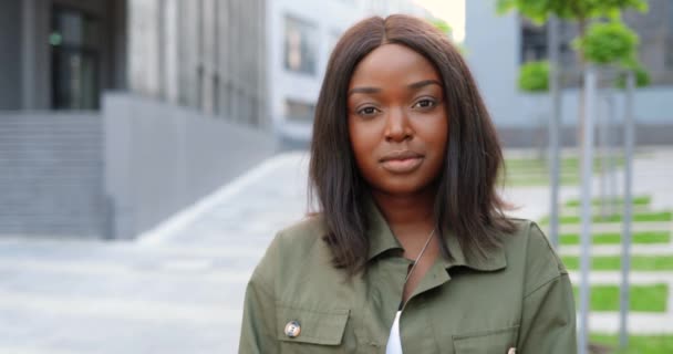 Portrait de jeune femme afro-américaine debout dans la rue de la ville et regardant la caméra avec le visage sérius. Gros plan de belle femme à l'extérieur — Video