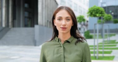 Güzel beyaz bir kadının portresi. Kameraya bakıyor ve dışarıda neşeyle gülümsüyor. Çekici, gülümseyen, neşeli bayanı yakından çek. Dolly vurdu. Yüze yakınlaştırıyorum..