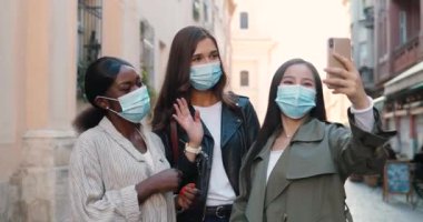Neşeli, beyaz, Asyalı, Afro-Amerikalı güzel bayanların görüntüsü. Web kamerasıyla konuşup sohbet ediyorlar. Video kaset takan melez genç kadınlar. Video 'da konuşan çok ırklı kızlar açık havada konuşuyorlar..