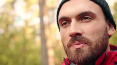 Şapkalı güzel beyaz turistin portresi ormanda duruyor ve dürbünle uzaklığa bakıyor..