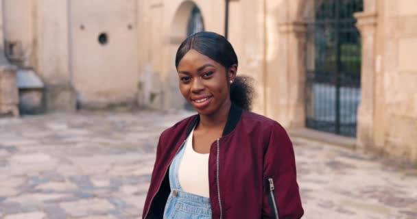 Porträtt av vackra afroamerikanska unga eleganta kvinna ser och ler mot kameran när du står i antika ruiner i stan. Utomhus. Vacker glad kvinnlig turist på trevlig arkitektur. — Stockvideo
