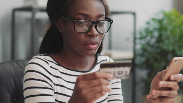 Close up de jovem mulher bonita fazendo compras on-line usando aplicativo móvel e cartão bancário. Serviço disponível. — Vídeo de Stock