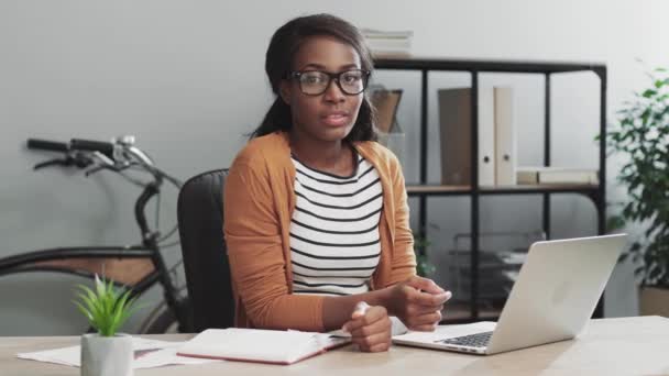 Portret van succesvolle jonge zakenvrouw zittend in modern kantoor op het werk en poserend voor de camera glimlachend. — Stockvideo