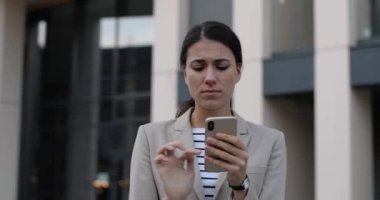 Kentte duran ve akıllı telefonda yazı yazarken öksüren genç, sağlıksız, beyaz kadın işçiyi yakından çek. Dışarıdaki cep telefonunda soğuk mesaj atan hasta bir kadının portresi. Sağlık kavramı