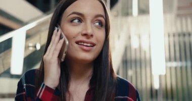 Kampüsün lobisinde durup arkadaşlarıyla telefonda konuşan güzel, beyaz bir kız öğrenciye yakın durun..