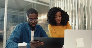 Birkaç Afrikalı Amerikalı öğrenci üniversite konferans salonunda oturup sınavlara hazırlanma görevlerini tartışıyor..