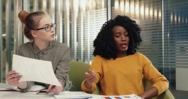 Genç çokuluslu zeki öğrenciler modern oditoryumda oturup final sınavlarına hazırlanıyorlar..