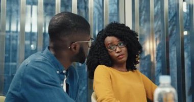 Gözlüklü genç profesyonel öğretmen iki öğrencinin ders konusunu anlamasına ve tahtaya grafik çizmesine yardımcı oluyor..