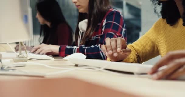 Primer plano de niña estudiante sentada en la sala de información y escribiendo en el teclado mirando la pantalla de la computadora. — Vídeos de Stock