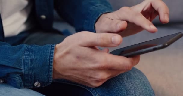 Primer plano del joven sosteniendo el teléfono inteligente en sus manos y escribiendo rápidamente el texto en pantalla. Usuario juega móvil juego. — Vídeos de Stock