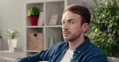 Kot gömlekli başarılı beyaz adamın portresi. Kanepede otururken kameraya bakıp gülümsüyor..