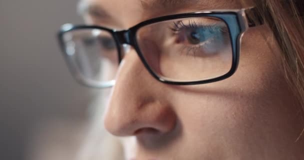 Close up af ung smuk kvinde i briller, der arbejder intenst på bærbar computer og ser intenst på skærmen. – Stock-video