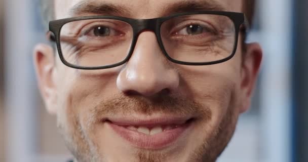 Närbild porträtt av stilig kaukasiska smart man tittar på kameran ler och justera glasögon. Vackra människor. — Stockvideo