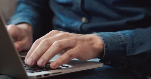 Primo piano della tastiera da digitare a mano maschile mentre si lavora sul computer portatile seduto a casa sul divano. Concetto di lavoro remoto. — Video Stock