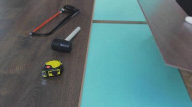 Adam daireye Laminate döşeme döşemesi kuruyor. İnşaat onarım dairesi. Çalışan adam lamine kuruyor. Dairenin tamiri, döşeme kaplaması. İnşaat.