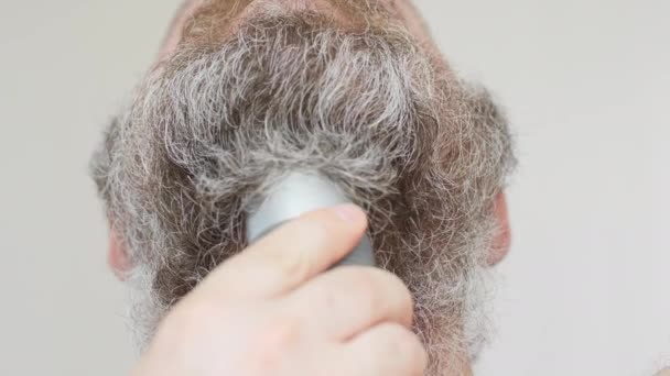 남자가 반회색 수염을 면도칼로 면도를 수염깎는 데쓰이지 이발소 클리퍼 가까이 — 비디오