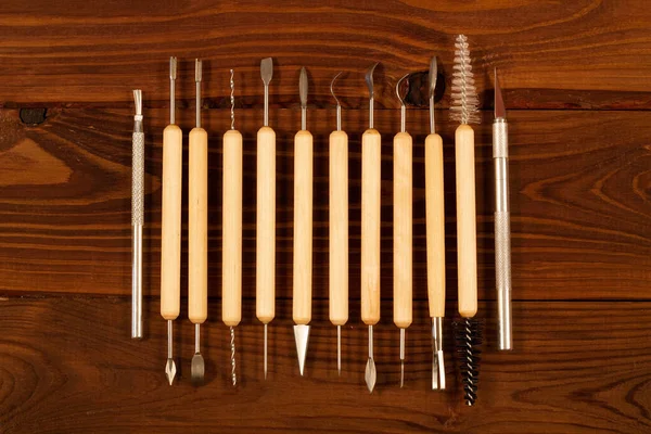 Professional sculpting tool kit for polymer clay and wax on brown background. Home Polymer Clay Tools set. Steel Tip Tools with Wooden Handles, for Pottery Modeling, Smoothing, Carving, Ceramics