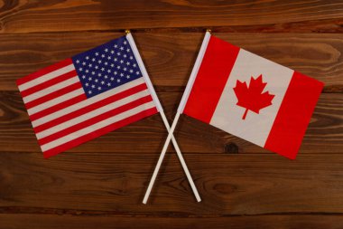 ABD bayrağı ve Kanada bayrağı birbirleriyle çarpıştı. ABD Kanada 'ya karşı. Görüntü ülkeler arasındaki ilişkiyi gösteriyor. Video haberleri ve internet ve medya makaleleri için fotoğrafçılık.