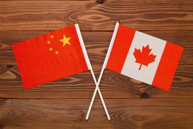 Çin bayrağı ve Kanada bayrağı birbirleriyle çarpıştı. Görüntü ülkeler arasındaki ilişkiyi gösteriyor. Video haberleri ve internet ve medya makaleleri için fotoğrafçılık.