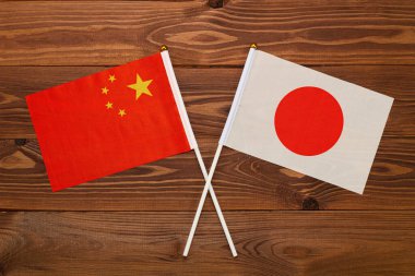 Çin bayrağı ve Japonya bayrağı birbirleriyle çarpıştı. Görüntü ülkeler arasındaki ilişkiyi gösteriyor. Video haberleri ve internet ve medya makaleleri için fotoğrafçılık.