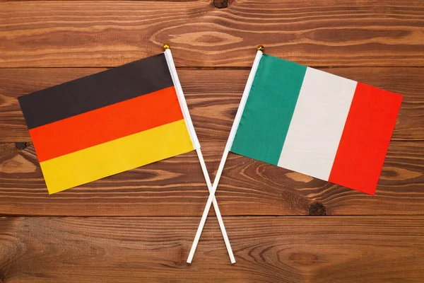 Flag of Germany and flag of Italy crossed with each other. The image illustrates the relationship between countries. Photography for video news on TV and articles on the Internet and media.