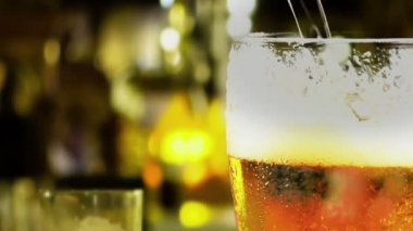 köpük bardak içine taze bira masaya pub arka plana dökme.