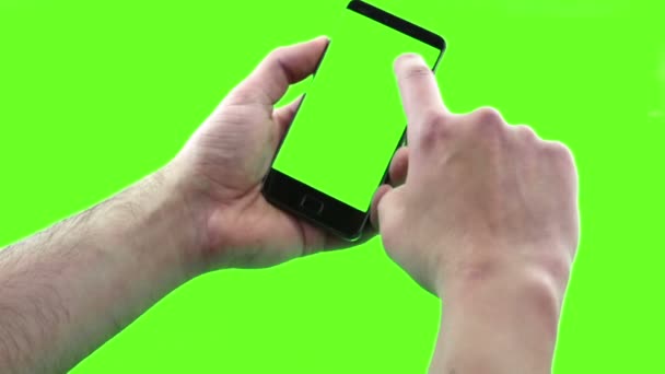 Тримаючи сенсорний екранний пристрій, крупним планом чоловіча рука використовує смартфон з ключем хроми, зелений екран на фоні, комунікація за допомогою технології смартфона — стокове відео