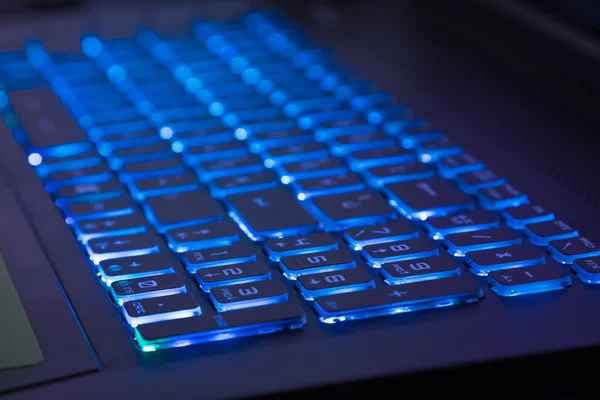 Close-up do teclado do notebook com tom de luz azul — Fotografia de Stock