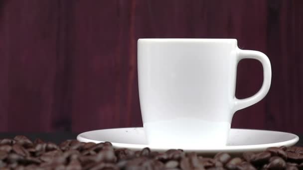 Xícara de café com fumaça em sementes de feijão torrado — Vídeo de Stock