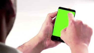 chroma anahtar görünüm, yeşil ekran, smartphone teknoloji kavramı ile yaşam tarzı iletişim arkasında beyaz arka plan ile bir akıllı telefon kullanan adam