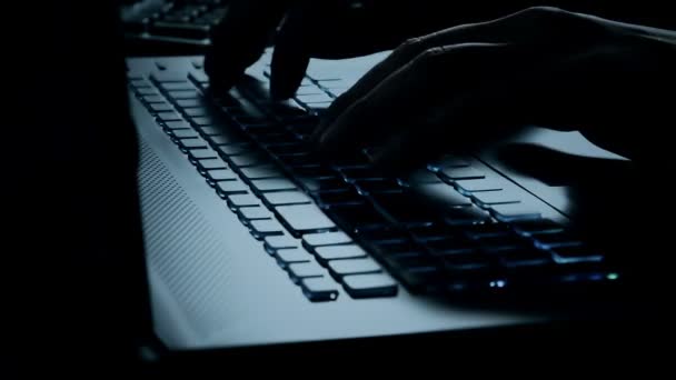 Hombre escribiendo en el teclado portátil con tinte de luz azul — Vídeo de stock