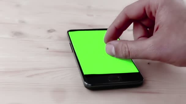 Man using a smart phone in the office with chroma key, green screen on wood table — Stock Video